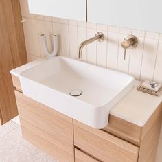 a bathroom sink sitting on top of a wooden cabinet