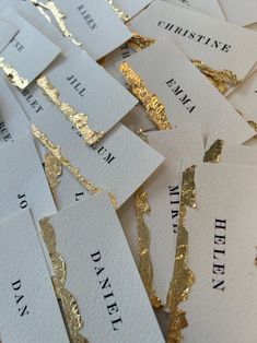 some gold foiled business cards are laying on top of each other