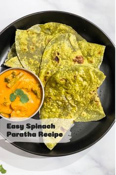 an easy spinach paratha recipe on a black plate with a bowl of sauce