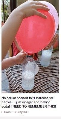 a person holding a red frisbee on top of a table with two plastic cups