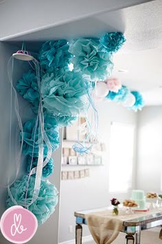 some blue flowers hanging from the side of a wall in a room with tables and chairs