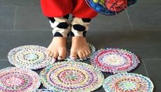 a person standing on top of a pile of crocheted rugs