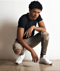 a young man sitting on the ground with his foot propped up in front of him