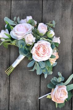 the bridal bouquet is laying on top of the wooden floor next to it's matching boutonnieres