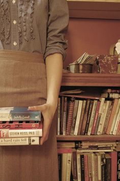 a woman holding a stack of books in her pocket