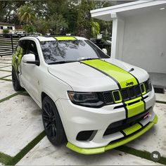 a white and yellow jeep parked in front of a house