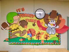 a bulletin board on the wall in a classroom with cartoon characters and clocks above it