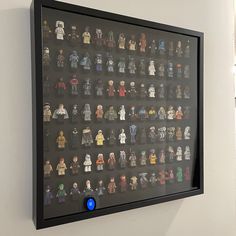 a display case filled with lego minifigures on a wall next to a window