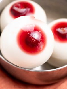 three hard boiled eggs with jelly on them in a metal bowl, ready to be eaten