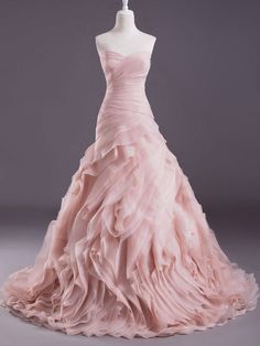 a pink wedding dress is displayed on a mannequin headdress with ruffles