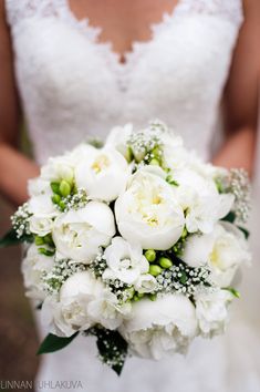 a bridal holding a bouquet of white flowers