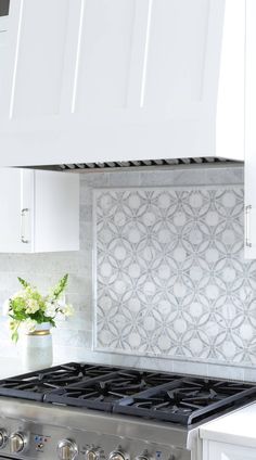 a stove top oven sitting inside of a kitchen next to a white countertop and cabinets