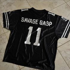 a black jersey with white stripes on the chest and number 11 on the front that says savage gasp