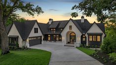 a large white house with lots of windows on it's front porch and driveway