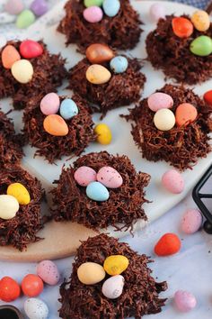 four chocolate nests with candy eggs in the middle on a white plate, ready to be eaten