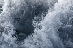 the water is white and foamy as it splashes up against the boat's hull