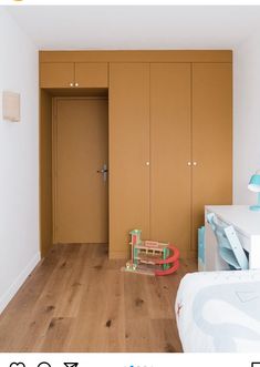 an empty bedroom with wooden floors and closets on the wall, next to a child's toy train