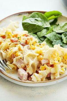 a white plate topped with pasta and spinach