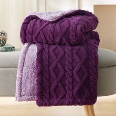 a purple blanket sitting on top of a wooden table