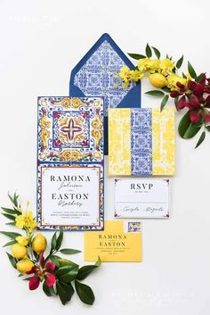 the wedding stationery is laid out on top of each other with yellow flowers and greenery