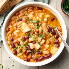 a white bowl filled with beans and potatoes