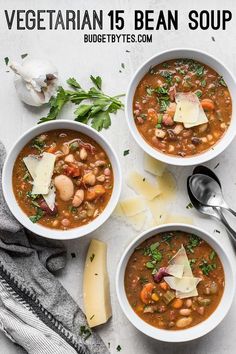 three bowls of vegetarian bean soup with parmesan cheese and herbs on the side