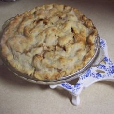 a pie sitting on top of a table next to a blue and white dish towel