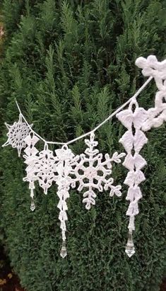 snowflakes hanging from a line in front of some bushes