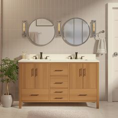 a bathroom with two sinks, mirrors and a plant on the floor in front of it