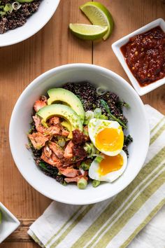 a bowl filled with rice, meat and avocado on top of a wooden table