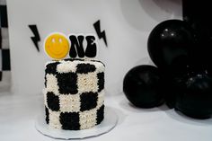 a black and white cake with a smiley face on top