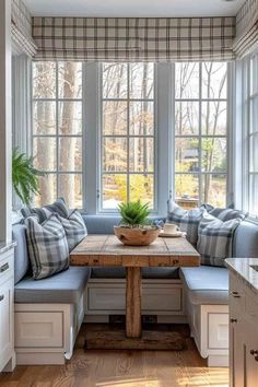 a wooden table sitting under a window in a kitchen