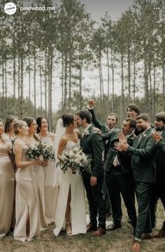 a group of people standing next to each other in front of some trees and grass