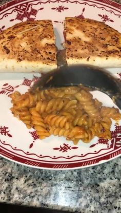 a plate with some food on it and a knife in front of the pizza slice