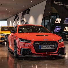 three different colored cars are on display in a showroom