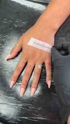 a woman's hand with a band on it and her nails in the middle