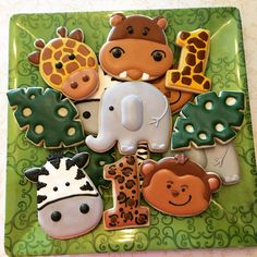 there are many decorated cookies in the shape of animals and giraffes on this plate