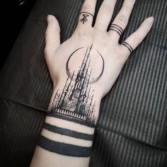 a person's hand with a black and white tattoo on it