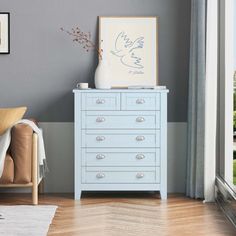 a blue dresser sitting in front of a window