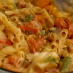 a pan filled with pasta and vegetables on top of a stove