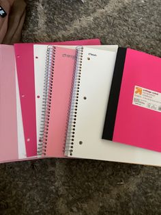 three spiral bound notebooks with pink and white covers