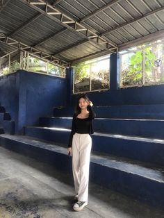 a woman standing in front of some blue steps