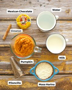 ingredients to make pumpkin pie sitting on top of a wooden table, including milk, sugar and cinnamon