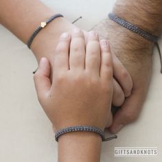 two people holding hands while wearing bracelets