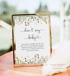 a sign that reads books for two babies on top of a wooden table with feathers