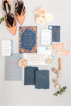 the wedding stationery is laid out on top of each other, including an orange and blue color scheme