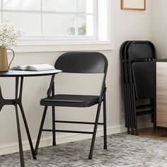 two black folding chairs sitting next to each other near a table with a book on it