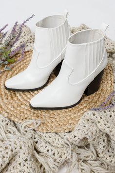 Add a dose of western flare to your next look with the Easy As That Ankle Boots! A white faux leather shapes these slip-on boots that have a western-inspired silhouette, pointed-toe, and ankle-high shaft with contrasting seam detailing. Complete with pull tabs on both sides for easy on and off. Elastic side detail + Faux leather + Slip on Pu leather 3" Heel height Keywords: White, Western, Boots, Pointed Toe White Western Boots, Western Ankle Boots, Blue Denim Pants, Athleisure Tops, Slip On Boots, Leather Slip Ons, Western Boots, Handbag Accessories, Blue Denim