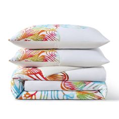 four pillows stacked on top of each other in front of a white background with multicolored leaves