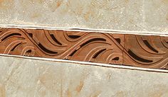 a close up view of an artistic design on the side of a building with brown and white marble